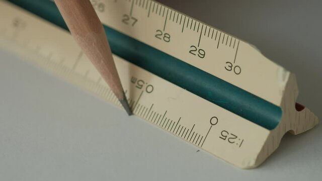 Close up, Male Hands using Triangle Scale Ruler with Wooden Pencil on White Paper, Drafting Tools.
