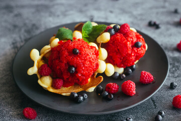 Delicious hong kong waffles. Waffles with strawberry ice cream and berries. Waffles on the table 