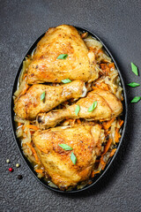 Spicy roasted chicken with vegetables on dark background. Space for text, top view.
