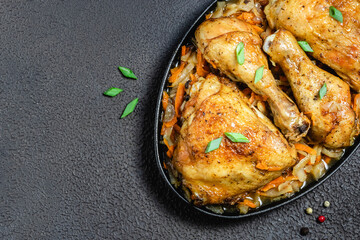 Roasted chicken with cabbage on dark background. Space for text, top view.