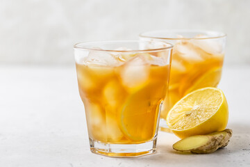 Summer party cocktail, iced lemon ginger tea in glasses. Space for text.
