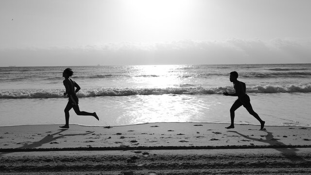 group of people running on beach