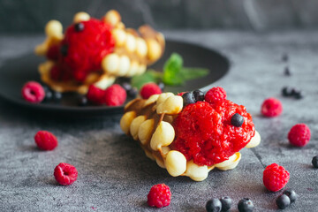 Delicious hong kong waffles. Waffles with strawberry ice cream and berries. Waffles on the table 