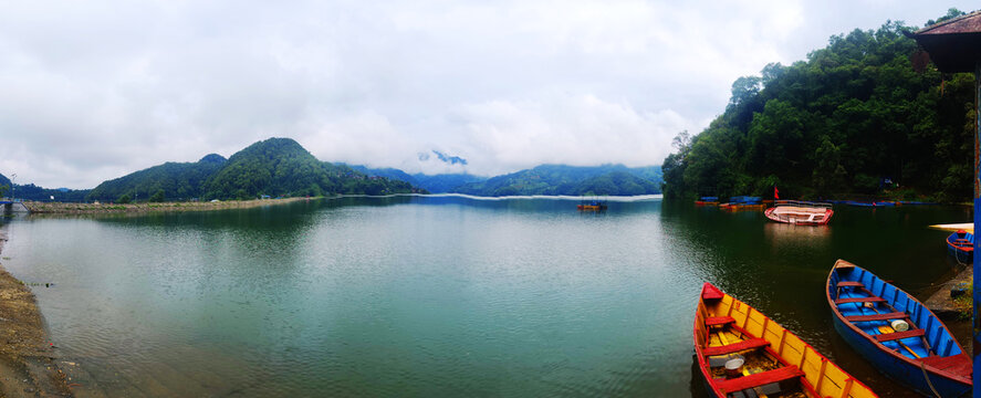 boats in calm lake water, Begnas Lake in Nepal.Pokhara Valley, a fishing boat in calm lake water, an old wooden fishing boat in still lake water.