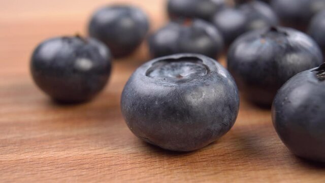 Ripe blueberries on a wooden surface. Macro. Dolly shot.