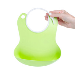 Green baby silicone bib in hand on white background isolation