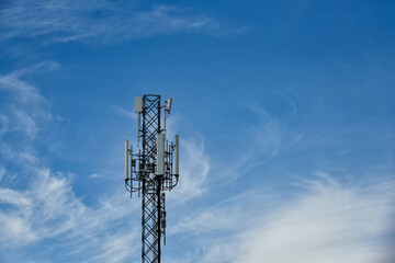 Telecommunication towers with motions clouds on blue sky background.