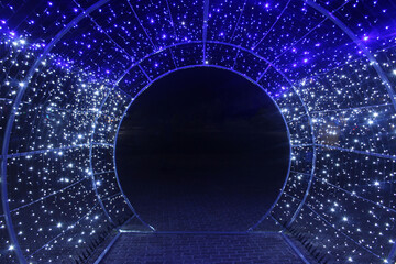 tunnel and illuminations of blue white on a black dark background. New Year's Eve Christmas....