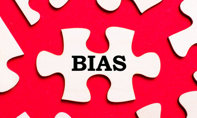 On a bright red background, white puzzles. In one of the pieces of the puzzle, the text BIAS
