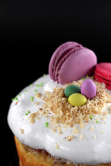 Easter cake with white cream decorated macaroons on a dark background. Easter traditions.	