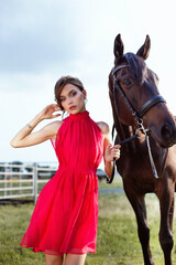 Portrait of a lovely young girl in a dress with a horse.