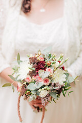 Bride holds a bridal bouquet in front of her. Chubby bride 