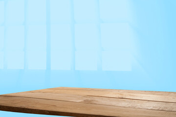 Empty table top made of natural wood, light rays from the window on the background of the wall. For product demonstration and installation