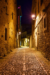Narrow alley in ancient stone village at night. Santillana del Mar, Santander.