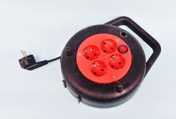 Rolling Cable Extension in black and red color in used condition isolated on color background