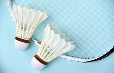 Badminton shuttelcock with racket as a background isolated on light blue color
