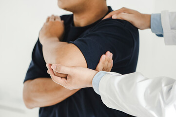 Closeup of a male Doctor or physiotherapist is doing stretching for a patient in the clinic for examining treating injured of arm and Doing the Rehabilitation therapy pain