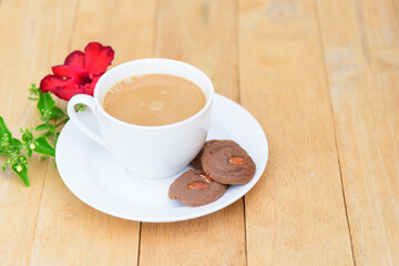 Top view of hot coffee with cookie on wood plate