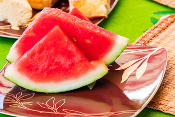 Sliced red watermelon on a brown plate