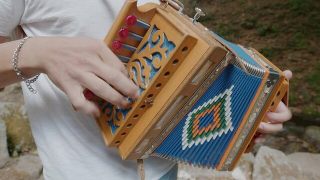 Giovane ragazza suona l'organetto calabrese in montagna