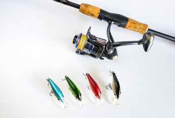 A fishing spinners and wobblers with fishing rod on background. Standard type of fishing lure.