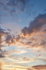 Beautiful evening blue sky at sunset with flaming bright light clouds. A warm summer evening at sunset. Bright sunset.