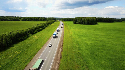 Beautiful landscape with a ride on the highway the trucks and a few cars at sunset. aerial view