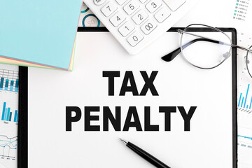TAX PENALTY on clipboard, calculator, graphs. Business concept. Flat lay.