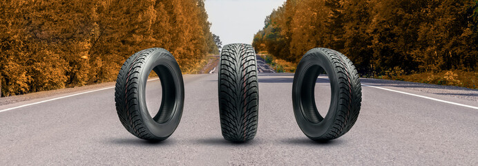 three all-season winter or autumn tires on the road in autumn with yellow leaves. preparing a car...