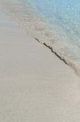 The blue sea water washed over the white sand.