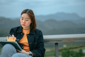 asian woman use tablet for stock and cryptocurrency trading from outdoor of coffee shop