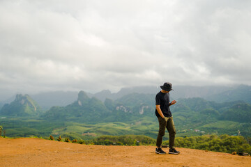 new normal outdoor lifestyle of man during travel on mountain and use phone for trading stock together