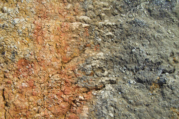 Dried black red clay surface. On the left, the clay is red. On the right, the clay is black. In the middle there is a transition between colors. Copy space, top view, textured, background.