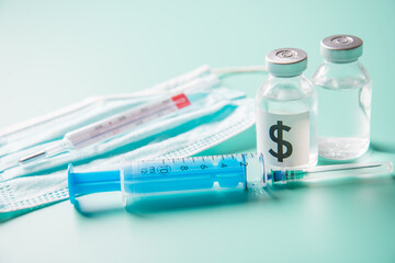 Vaccine for Covid-19 with protective mask, injection and thermometer on light green background.