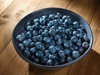 Blueberries in a blue bowl on a wooden table