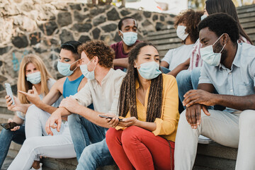 Diverse friends in masks talking on steps during pandemic