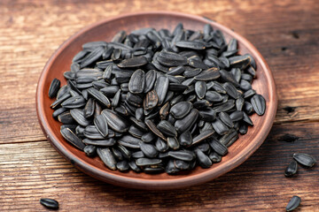 Black sunflower seeds on a wooden background.