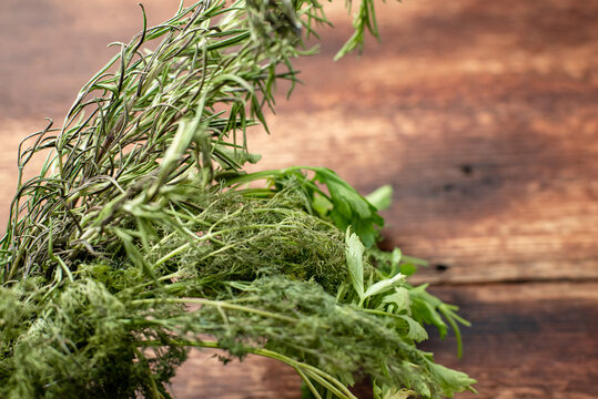 Perishable, fading, drying greens dill parsley on a wooden background.