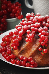 A cake with fresh red currant and tea