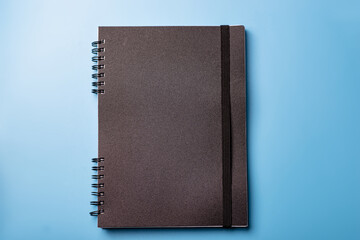 Black notebook on a blue background. Training, diary concept.