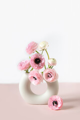 Tender ranunculus flowers in ceramic vase