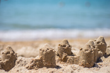 Fototapeta na wymiar Sand castle standing on the beach. Travel vacations concept.