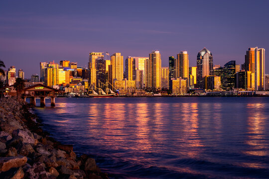 Sunset reflections from the skyline of San Diego California with a purple skies and water