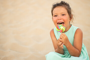 Cute little girl with big colorful lollipop. Child eating sweet candy bar. Sweets for young kids. Summer outdoor fun.