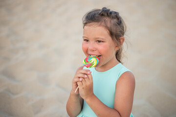Cute little girl with big colorful lollipop. Child eating sweet candy bar. Sweets for young kids. Summer outdoor fun.
