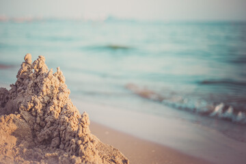 Sand castle standing on the beach. Travel vacations concept.