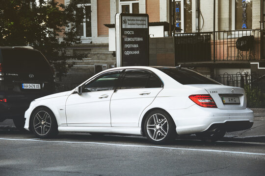 Kiev, Ukraine - May 22, 2021: White Mercedes-Benz C250 with AMG numbers is parked in the city