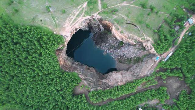 a lake in the mountains, formed as a result of a mine failure. a beautiful unusual place, a natural phenomenon-the Tuimsky failure in Khakassia Russia. aerial view of the forest and mountains from
