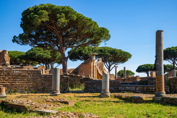 Rome Ostia Antica site, ruins of marble columns with brick buildings from the imperial era a in the archaeological park of Ostia Antica in summer with blue sky. Rome Italy, Europe.