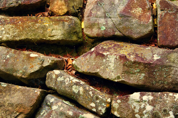 A close up of an old stacked stone wall.